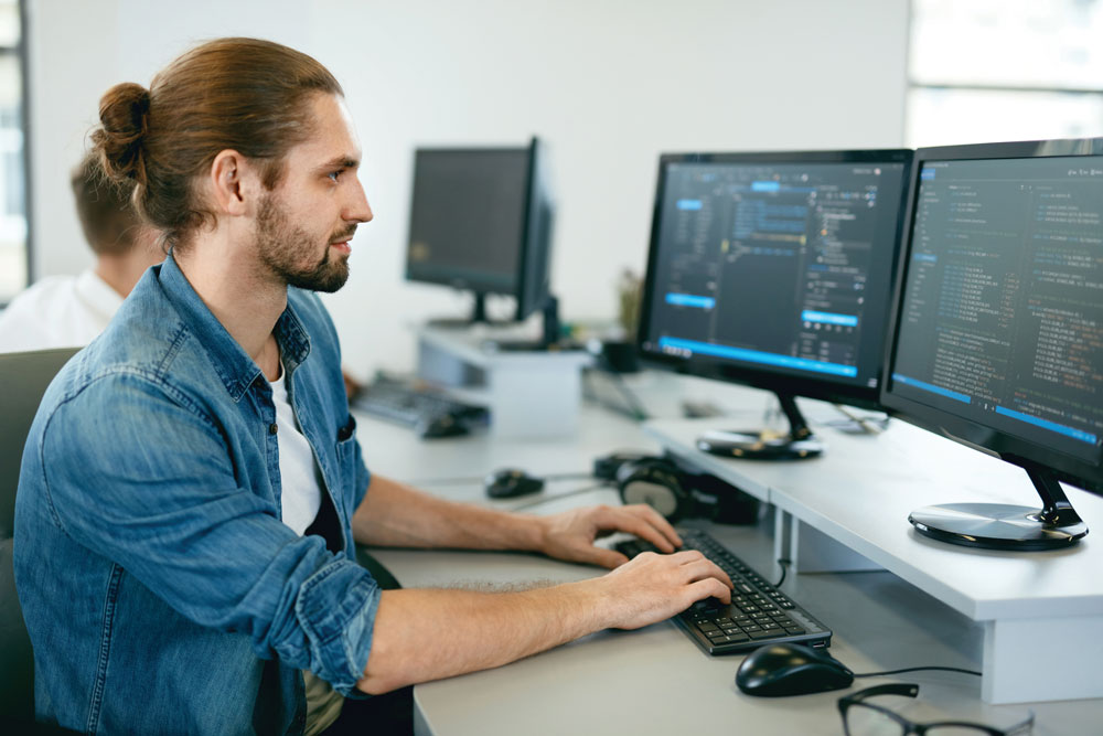 A guy working on a computer, Kramer's control programming services