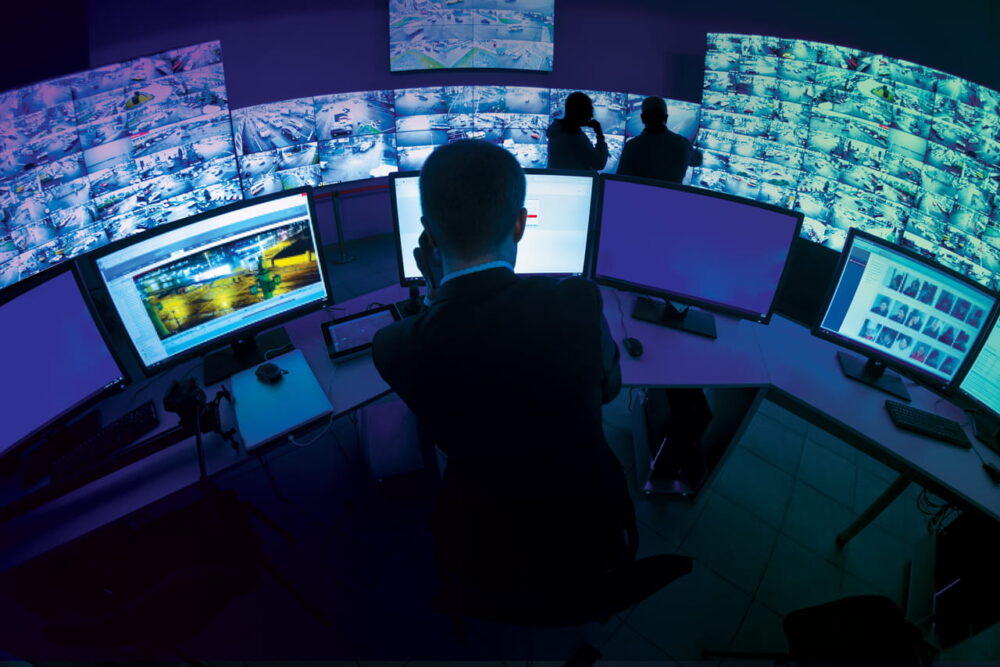 A person sitting in front of screens for an advance control expeience