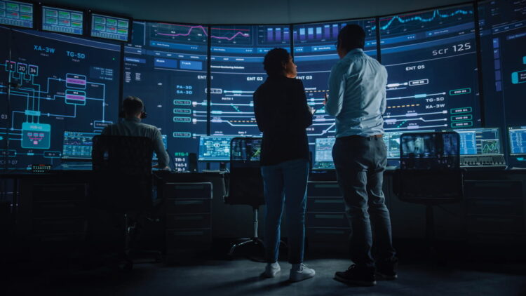 People in a control room, discussing numerous screens, using Kramer Series 3 devices