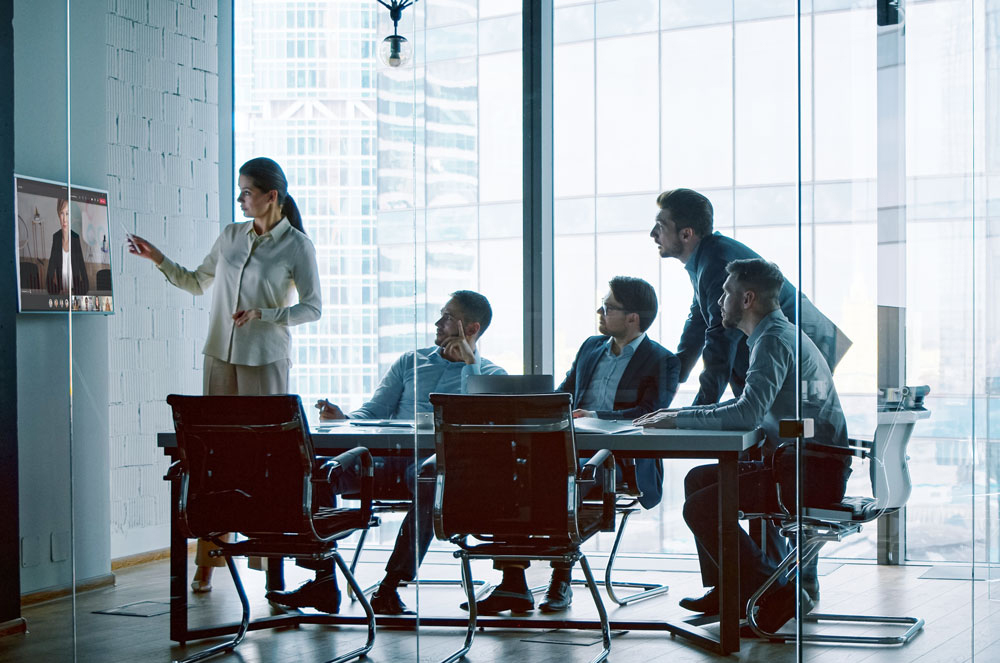 People sitting in a hybrid meeting room, using Kramer and Yealink joint solutions