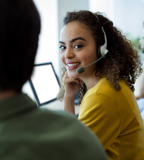 A woman wearing a headset, smiling at the camera