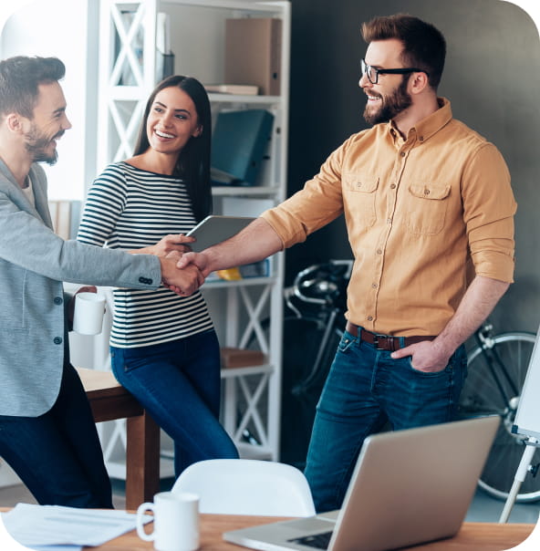 Three people meeting, laughing together, two of them shaking hands