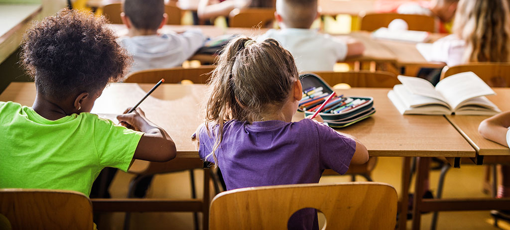 Pupils sitting next to their desks