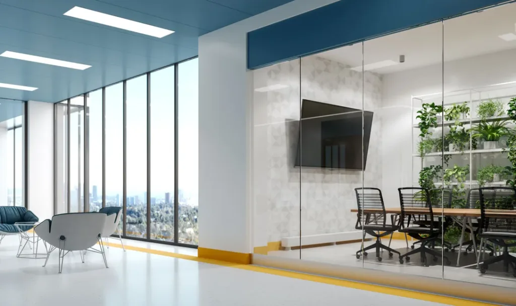 A large office space, with a meeting room at the side, in which Kramer's meeting room solutions are installed