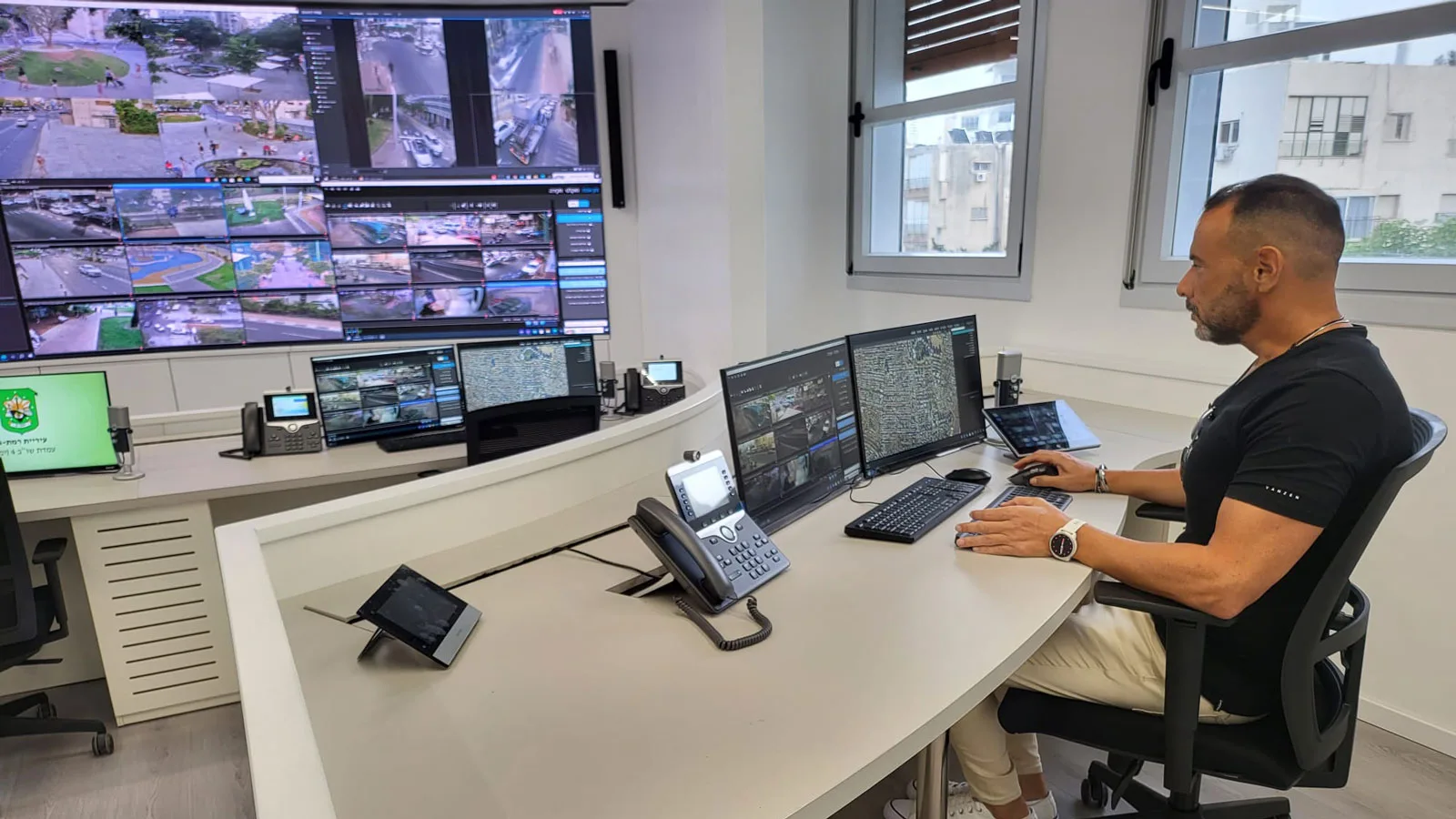 A man sitting near a computer at Ramat Gan municipality's command & control room, in which Kramer's Control and AVoIP solutions are installed