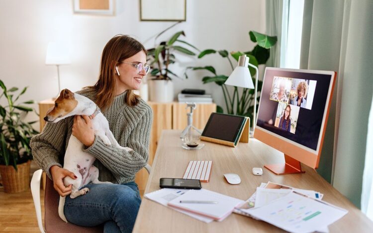 A woman during a meeting, holding her dog